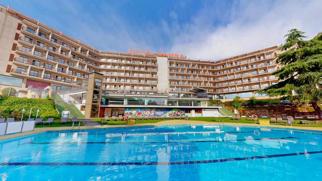 a large swimming pool in front of a hotel at Hotel Samba in Lloret de Mar