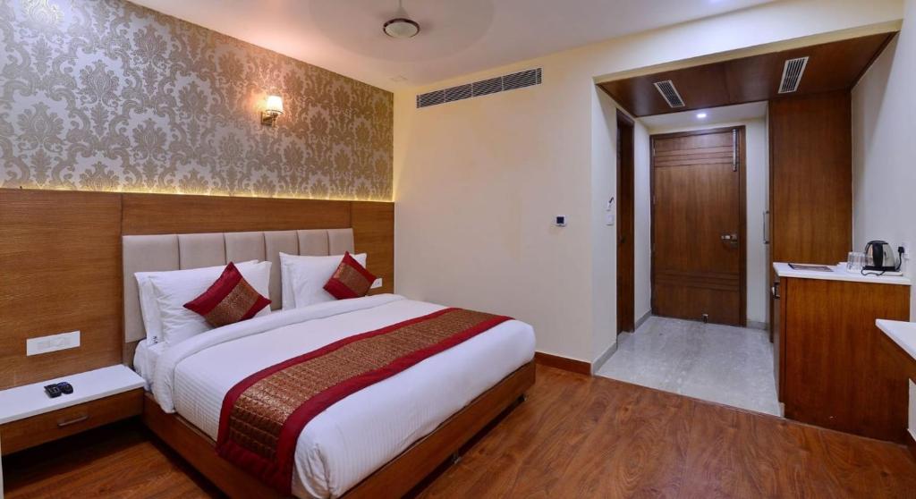 a hotel room with a bed and a bathroom at Hotel Smart Plaza Delhi Airport in New Delhi