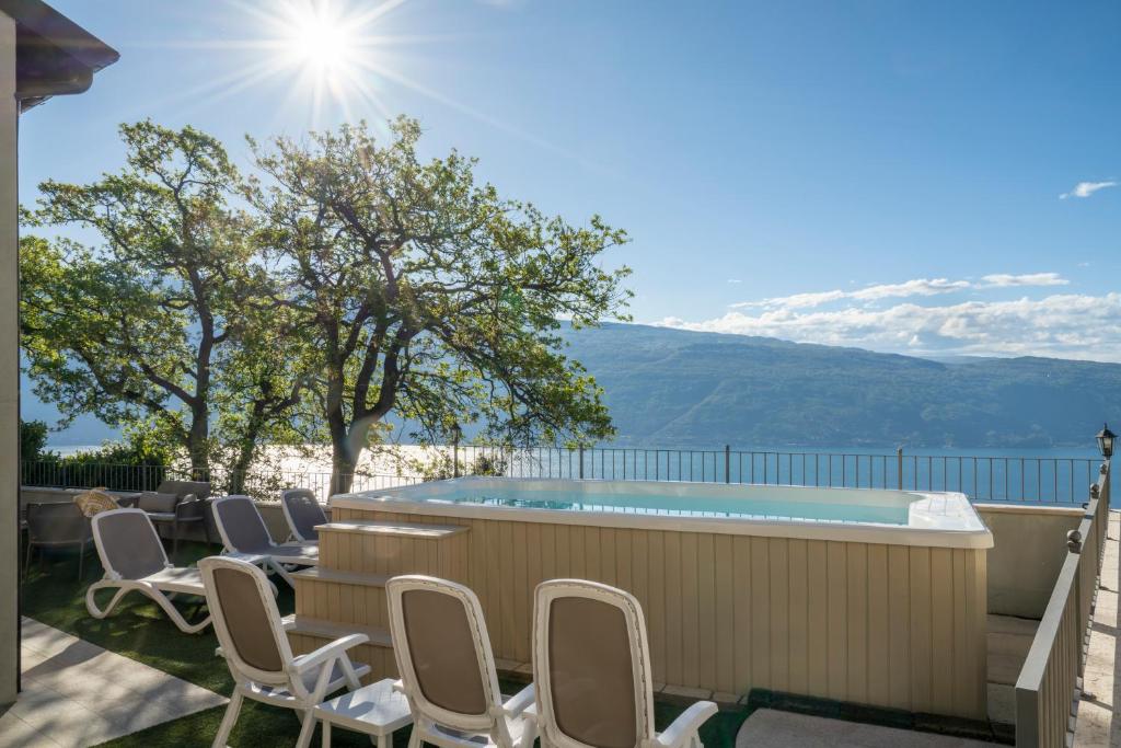 eine Terrasse mit Stühlen und einem Pool in der Unterkunft Piccola Meraviglia Sul Garda in Muslone