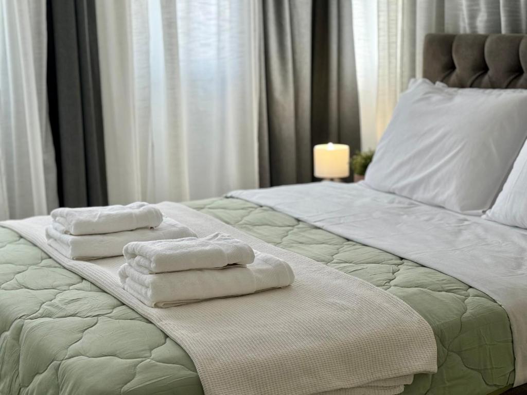 a bedroom with two folded towels on a bed at Kallithea Central Apartment in Kallithea Halkidikis