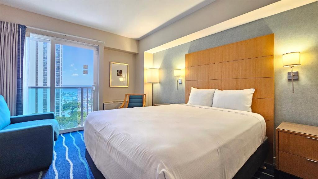 ホノルルにあるOcean View Room at a resortの大きなベッドと窓が備わるホテルルームです。