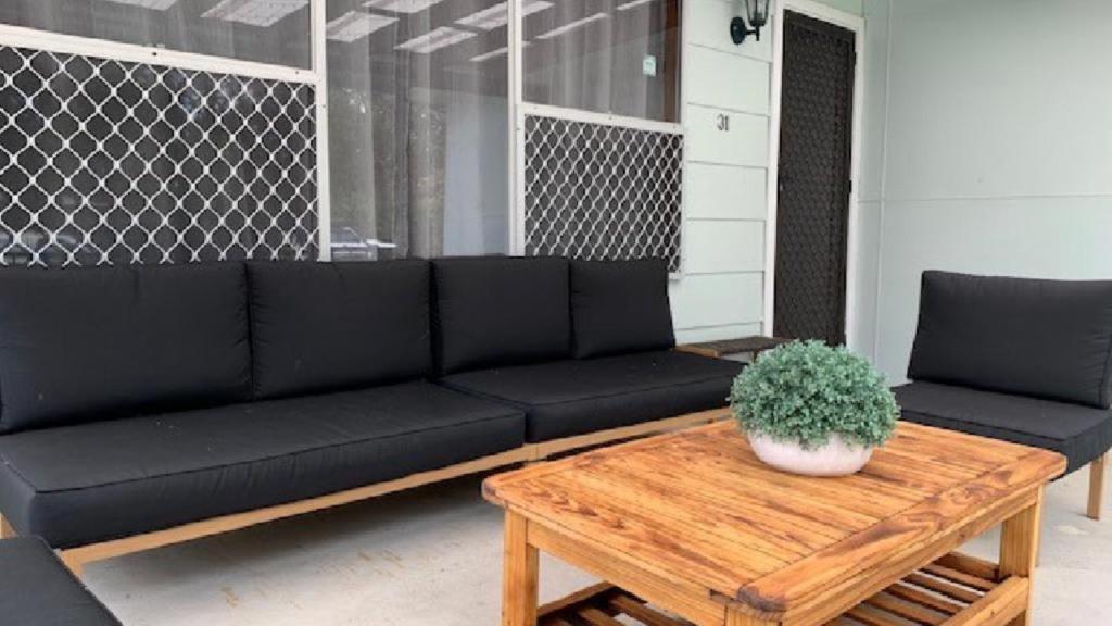 - un salon avec un canapé noir et une table basse dans l'établissement Best Family Beach Cottage!, à Hawks Nest