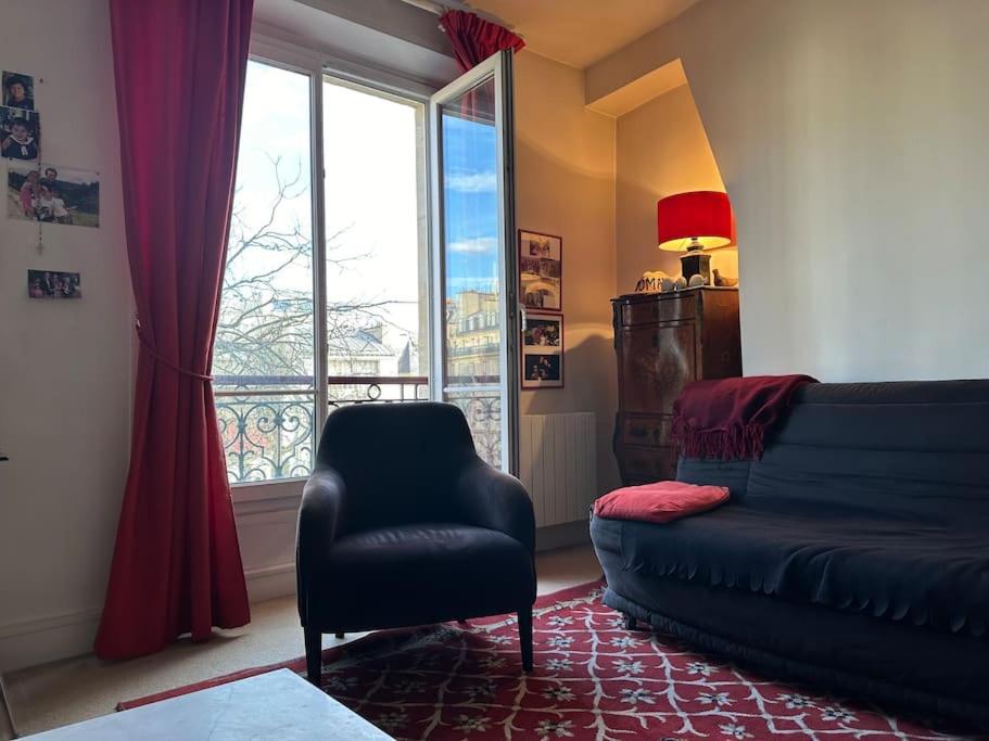 - un salon avec un canapé, une chaise et une fenêtre dans l'établissement Lumineux appartement de 47m2 dans le 17eme, à Paris