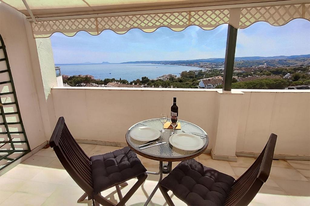 - une table et des chaises en verre avec vue sur l'océan dans l'établissement Jabeque 1 Dormitorio, à Estepona