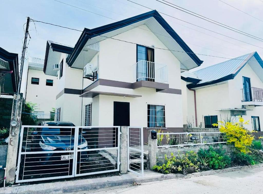 ein weißes Haus mit einem Zaun davor in der Unterkunft 3 Bedroom House near Davao Airport in Davao City