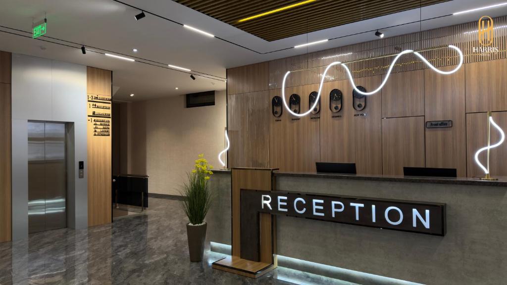 una reception nella hall con un cartello di ricezione di Harris Hotel a Tashkent