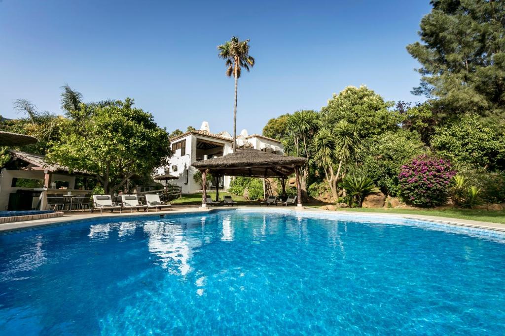 a large blue swimming pool in front of a house at Villa Bermeja in Casares