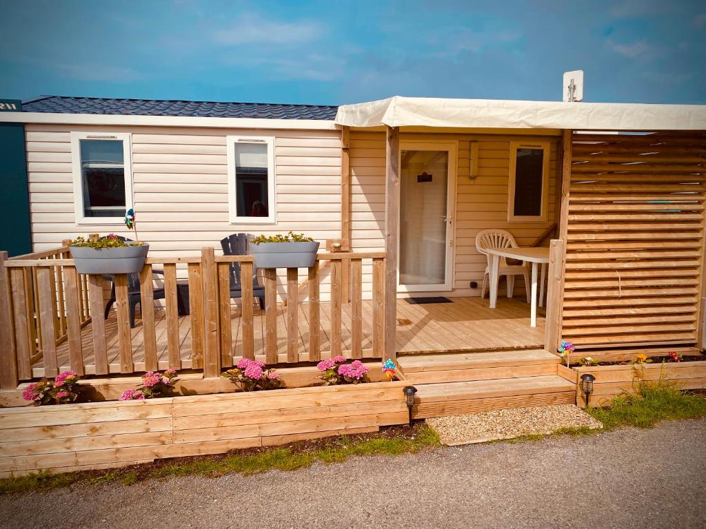 a wooden cabin with a porch and a deck at Mobilhome P27 6 personnes climatisé in Le Portel