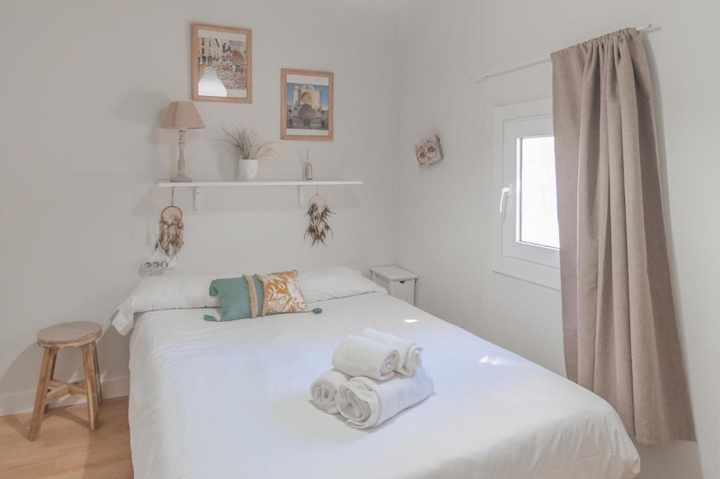 ein Schlafzimmer mit einem weißen Bett und Handtüchern darauf in der Unterkunft Clauhomes Oh La Lá in Tarragona