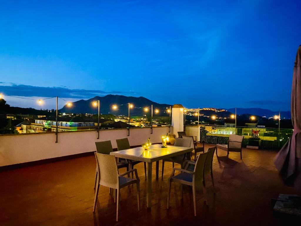 ein Tisch und Stühle auf einem Balkon in der Nacht in der Unterkunft Way2Rome Apartments in Rignano Flaminio