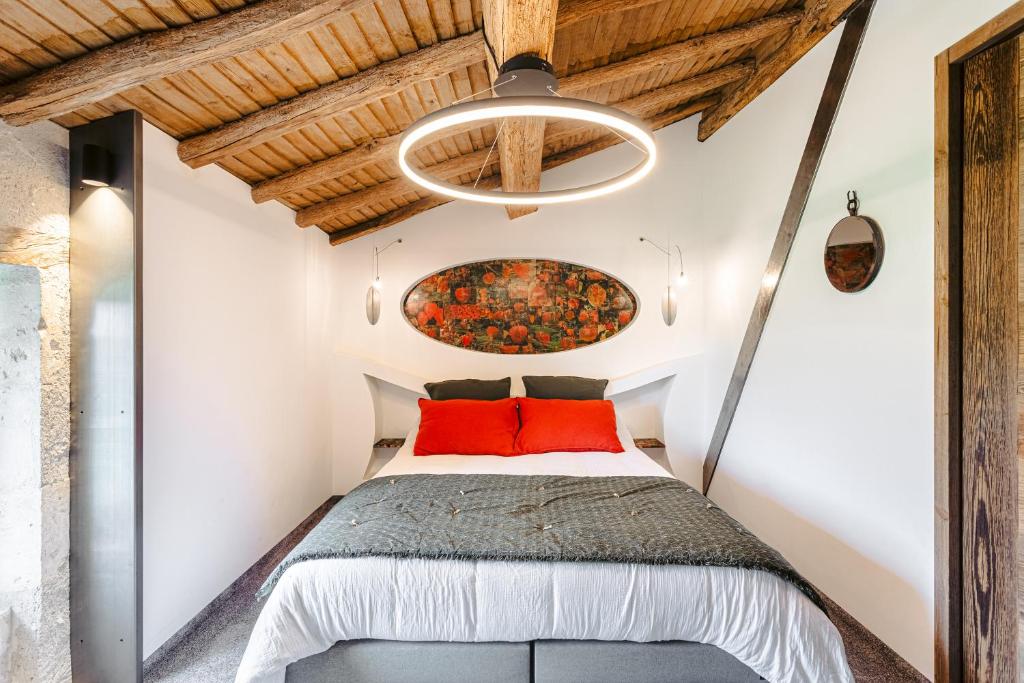 a bedroom with a bed with a painting on the wall at Gite les 3 piliers in Pissotte