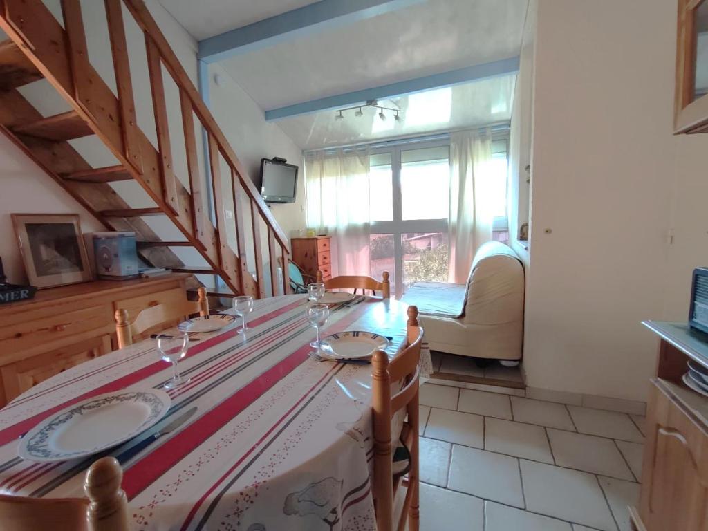 - une salle à manger avec une table et des verres à vin dans l'établissement Appartement à 25m de la plage - 4LBM359 Narbonne Plage, à Narbonne-Plage