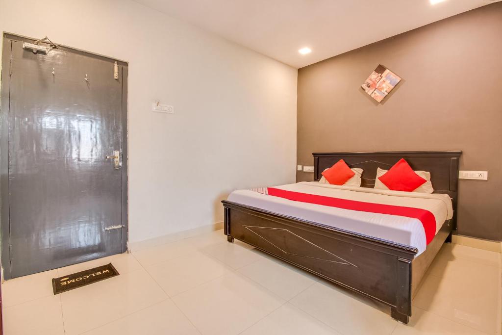 1 dormitorio con cama con almohadas rojas y ducha en OYO Flagship Our Palace en Gunadala