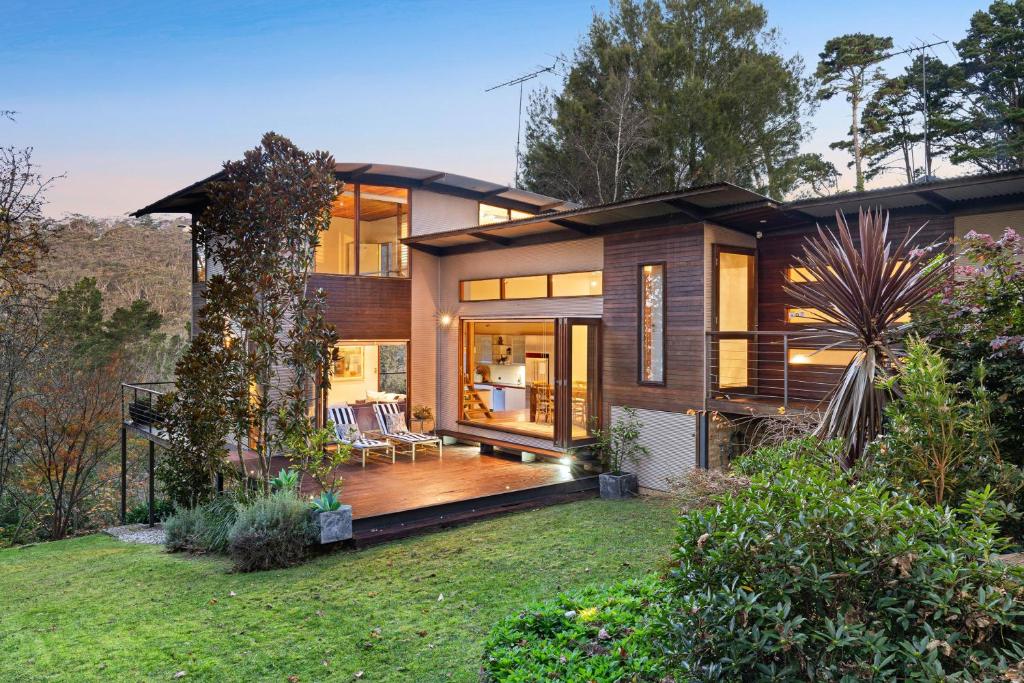 a large house with a large deck in a yard at Mountain Nest - LEURA in Leura