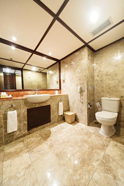 a bathroom with a toilet and a sink at Waterfront Airport Hotel and Casino in Mactan