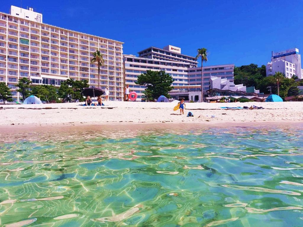 vista su una spiaggia con un hotel sullo sfondo di Hotel Sanrakuso a Shirahama