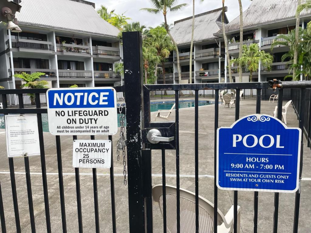 a fence with signs on it with a pool at Studio in Hilo Center with Pool and Lake Views in Hilo