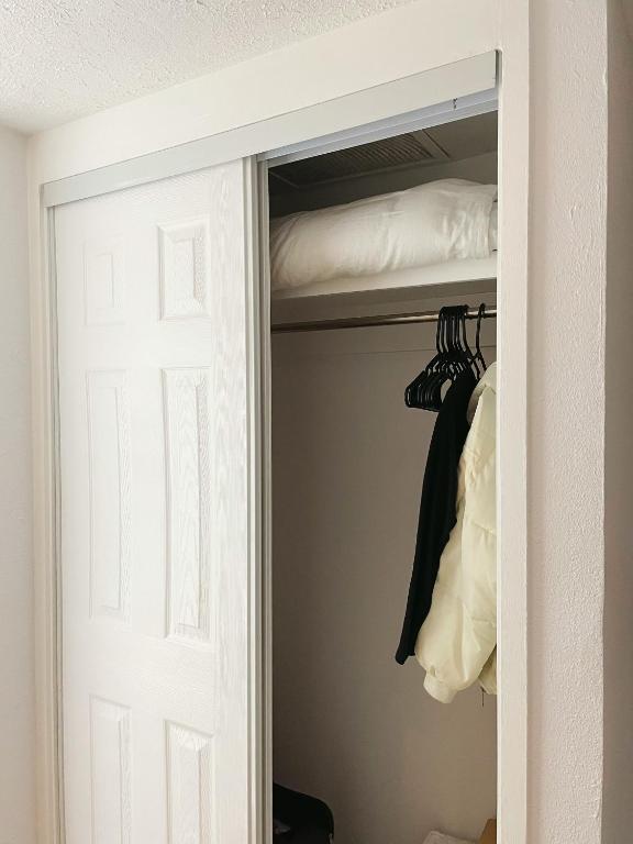 a closet with a door and a bed at Studio in Hilo Center with Pool and Lake Views in Hilo