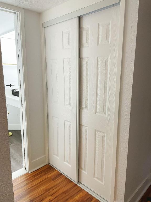 a closet door in a room with wood floors at Studio in Hilo Center with Pool and Lake Views in Hilo