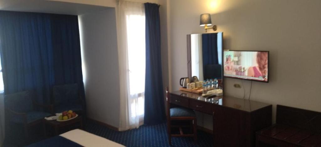 アレクサンドリアにあるAmon Alexandriaのデスクと窓が備わるホテルルームです。