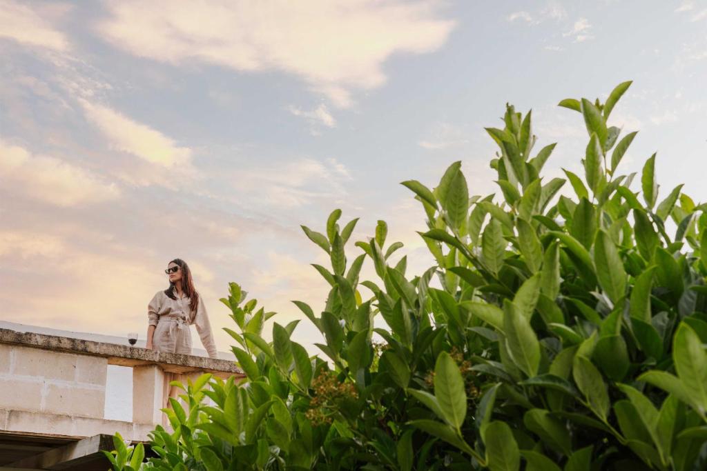 a woman standing on a ledge of a building at Masseria della Piana in Villanova di Ostuni