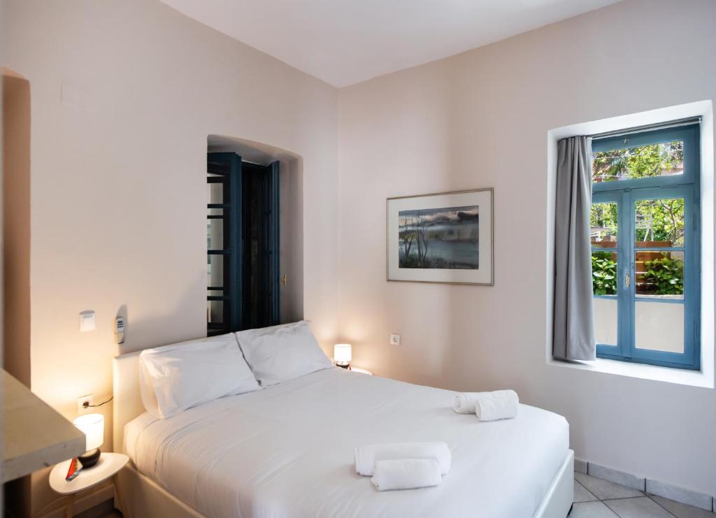 una camera da letto con un letto bianco e una finestra di AV Suites - Vivian a Kariá