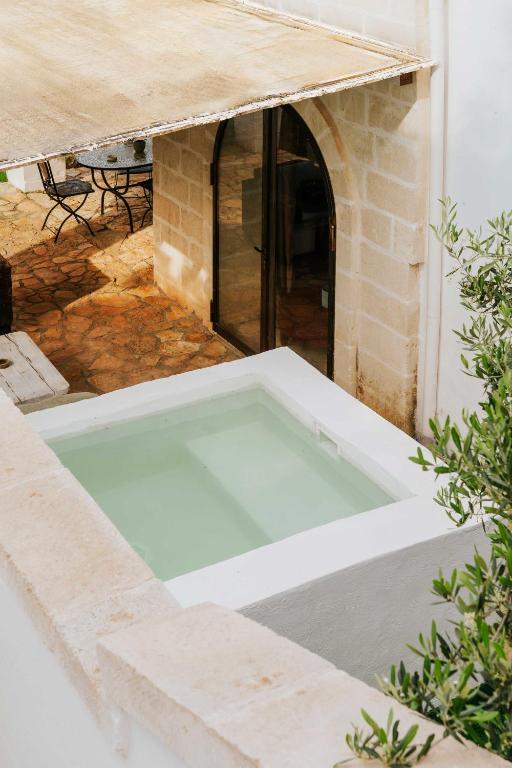 a swimming pool in the middle of a building at Masseria della Piana in Villanova di Ostuni
