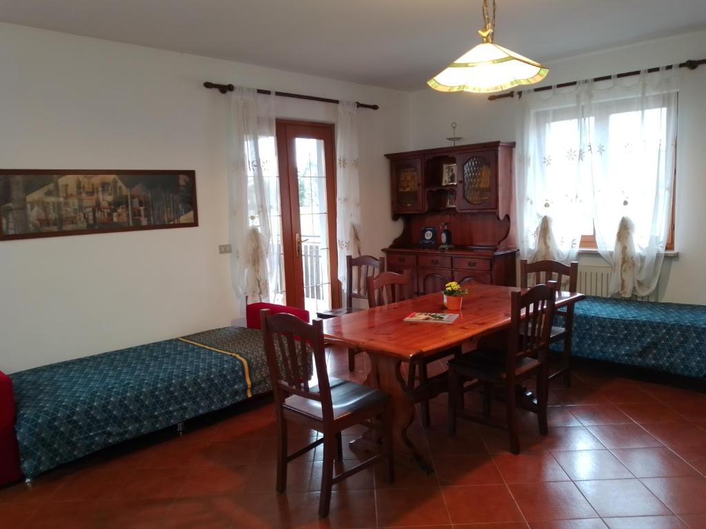 - une salle à manger avec une table et des chaises en bois dans l'établissement Cjase Paola, à Cassacco