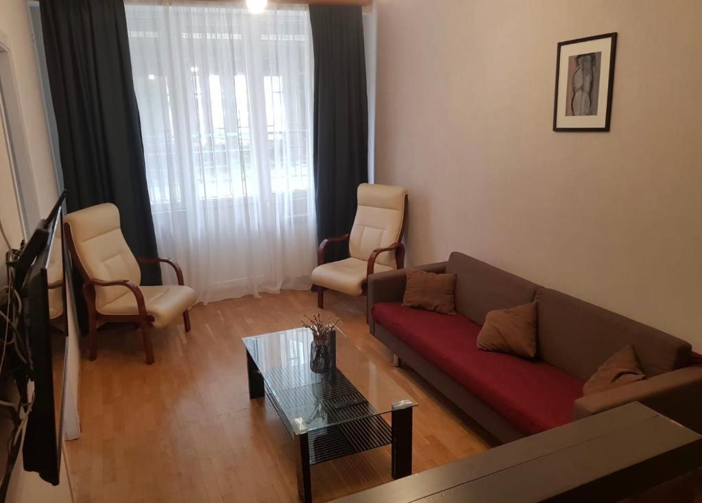 ein Wohnzimmer mit einem Sofa, Stühlen und einem Tisch in der Unterkunft beautiful flat/apartment in Tbilisi City