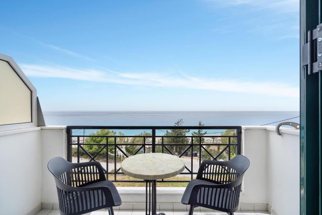 een balkon met een tafel en stoelen en uitzicht op de oceaan bij Sunset Premium Studio 8 in Ayios Nikitas