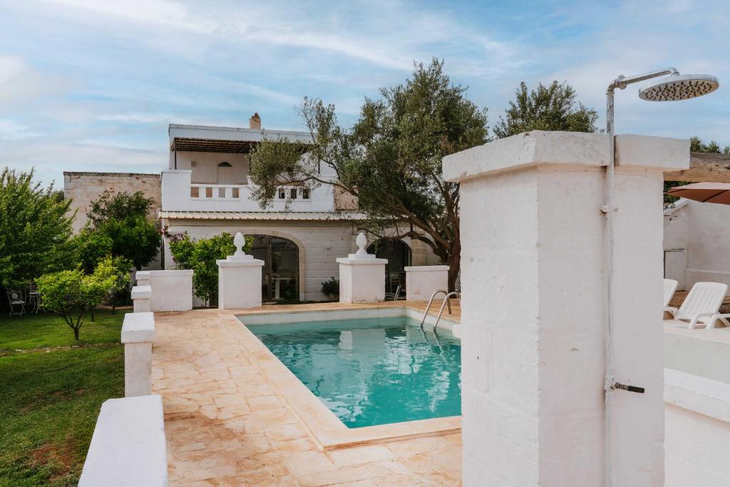 a swimming pool in front of a house at Masseria della Piana in Villanova di Ostuni