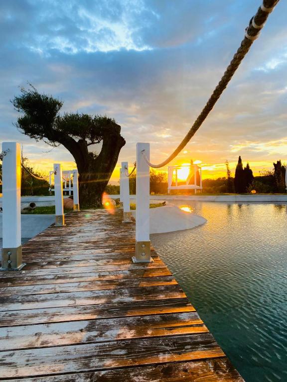 a bridge over the water with a sunset in the background at Agriturismo Cerrosughero in Canino