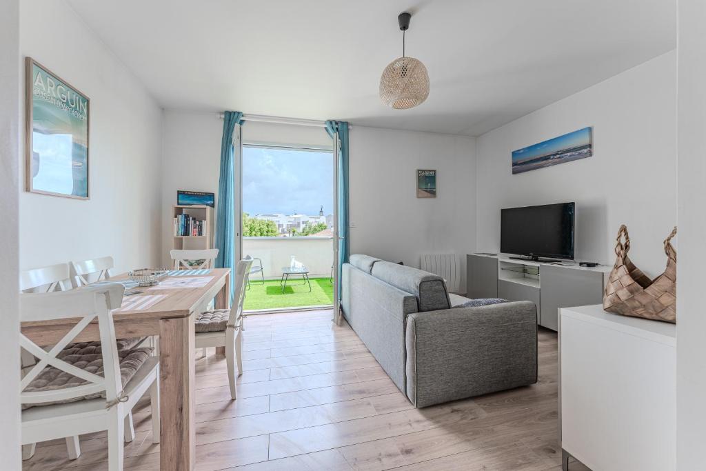 un salon avec une table et une salle à manger dans l'établissement La Teste coeur de ville, à La Teste-de-Buch