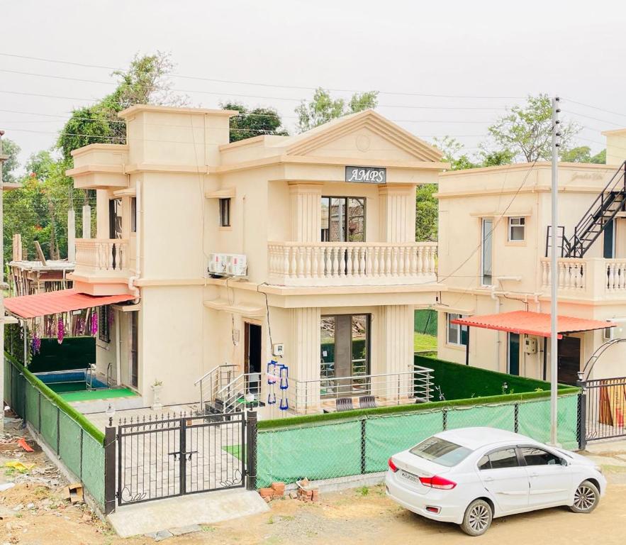 une voiture blanche garée devant un immeuble dans l'établissement AMPS Villa, à Wada