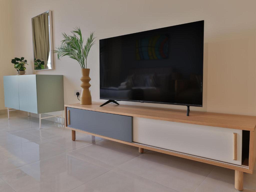 a living room with a large flat screen tv at Luxury Apartments Business Bay Gym Pool Parking by Sojo Stay in Dubai