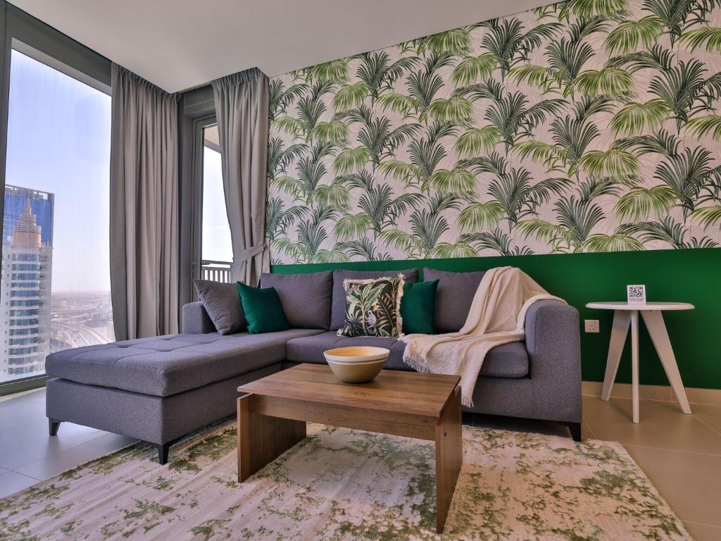 a living room with a blue couch and a green wall at Luxurious Apartments Dubai Marina Views Pool Gym by Sojo Stay in Dubai