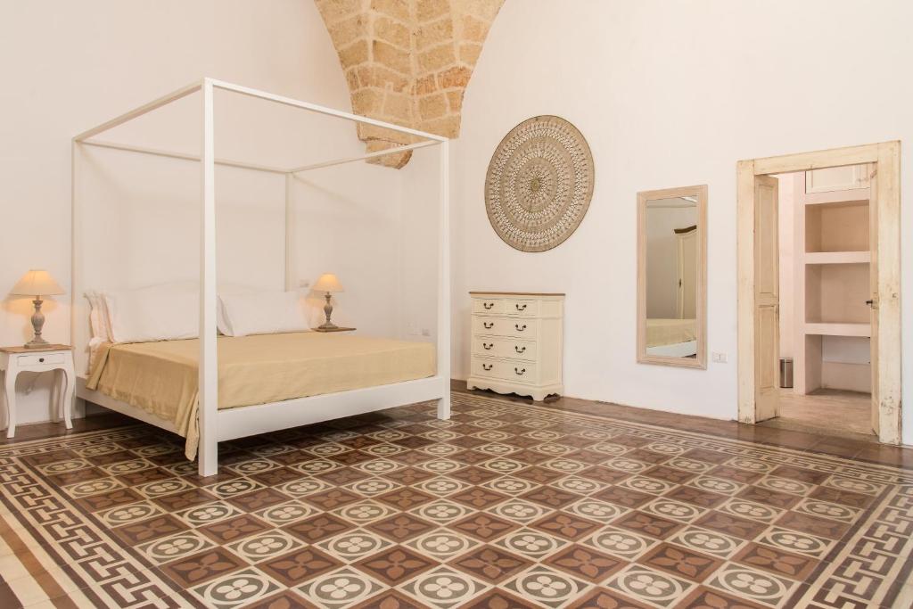 a bedroom with a canopy bed and a mirror at Di Lorenzi Albergo Diffuso in Felline