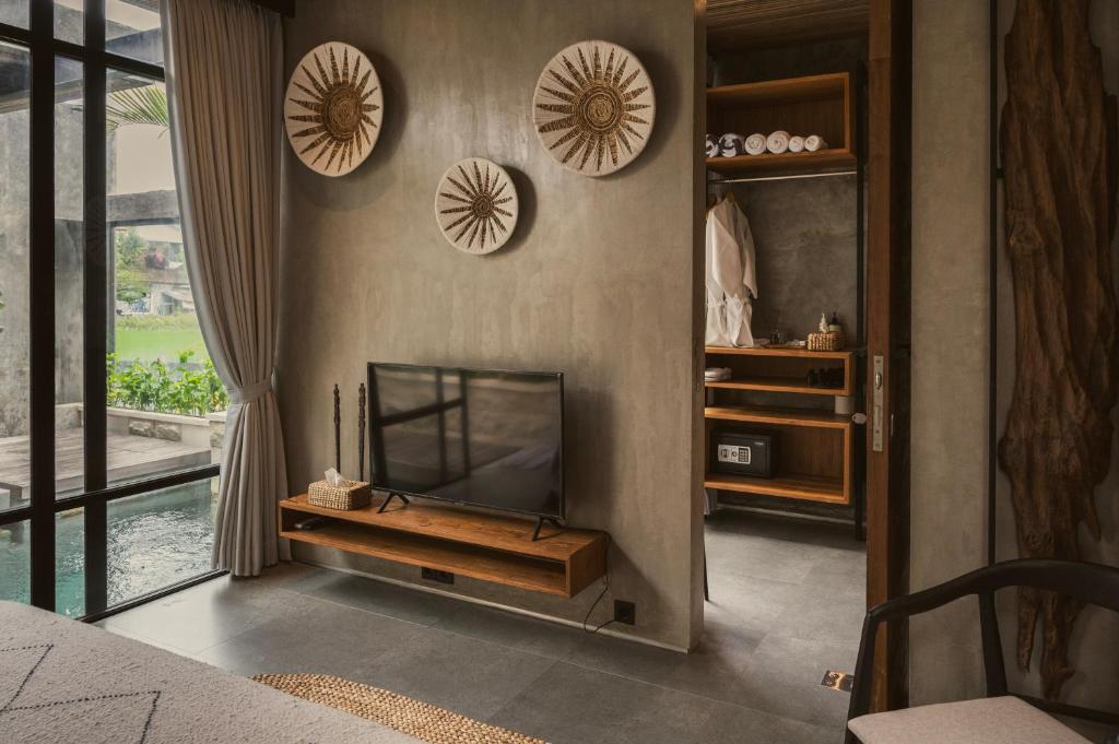 Danu Villas Bali في كيروبوكان: غرفة معيشة مع تلفزيون بشاشة مسطحة على جدار