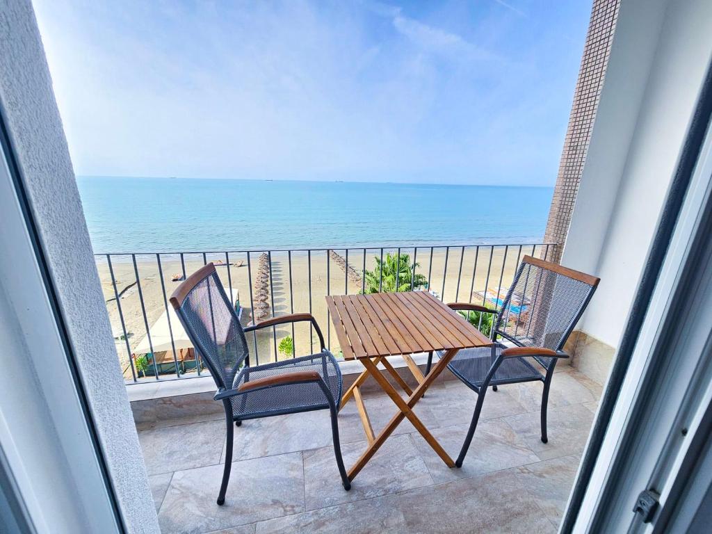 einen Tisch und Stühle auf einem Balkon mit Meerblick in der Unterkunft No1 apartment 711 in Durrës