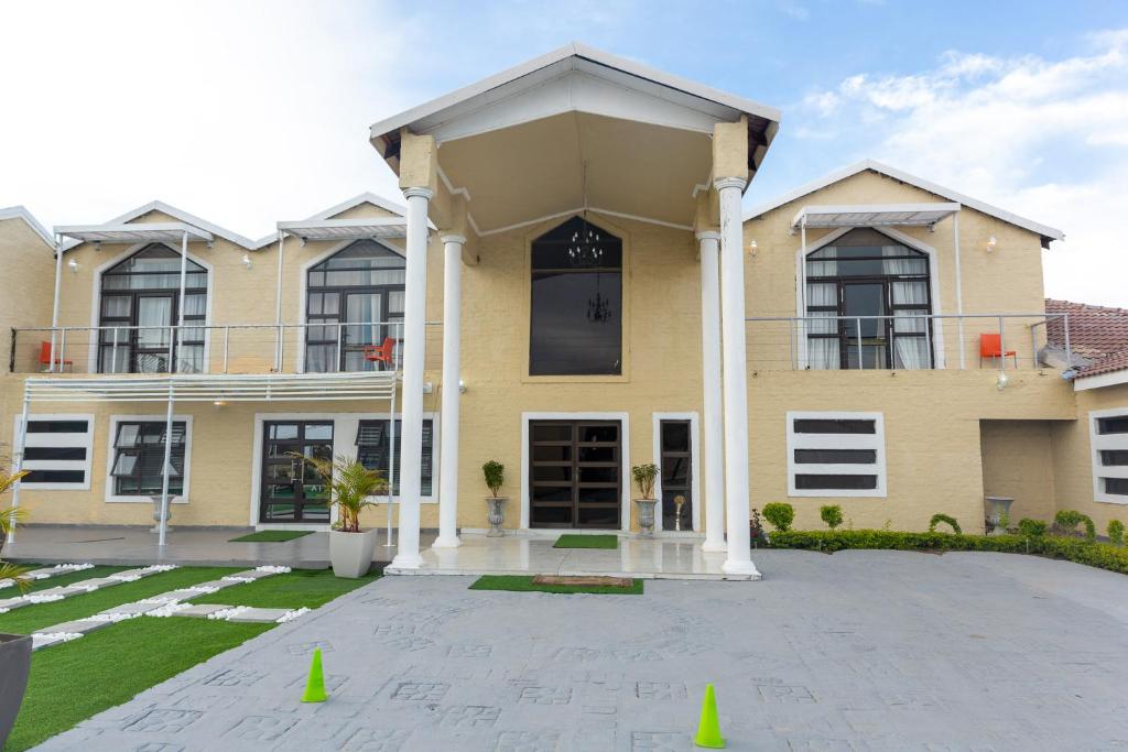 a large yellow building with a lot of windows at Polokwane Estate Lodge & Spa in Polokwane