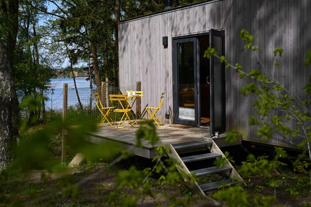 a house with a deck with a table and chairs at Tiny House Pioneer 2 - Salemer See in Salem