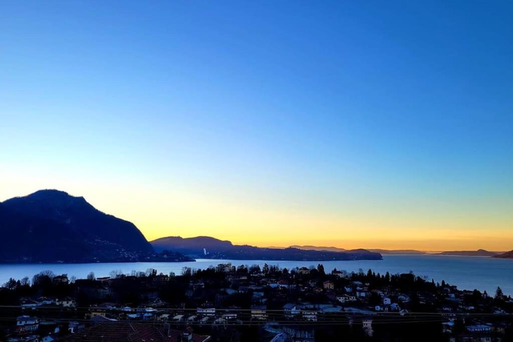 a view of a city and the ocean at sunset at Overlooking Lago Maggiore in Verbania