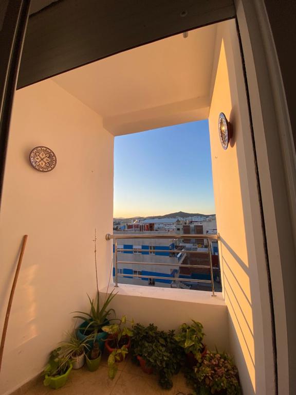 een kamer met een raam met uitzicht op een gebouw bij Appartement près de la plage in Martil