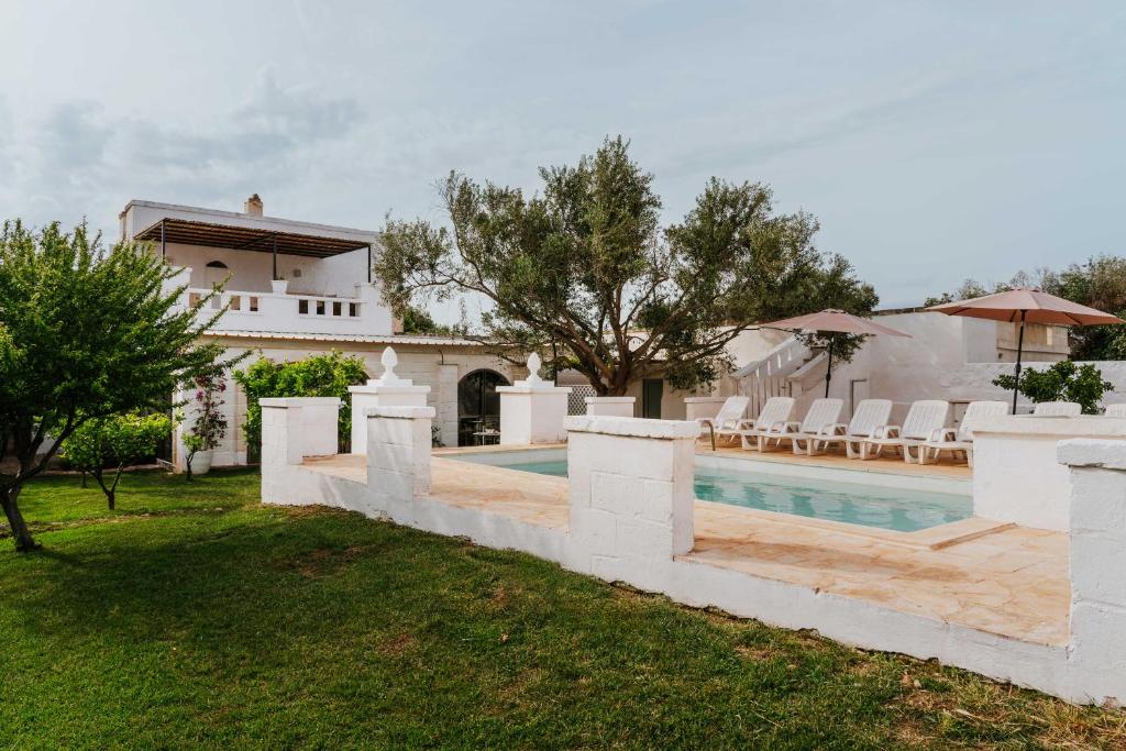 a villa with a swimming pool and a house at Masseria della Piana in Villanova di Ostuni