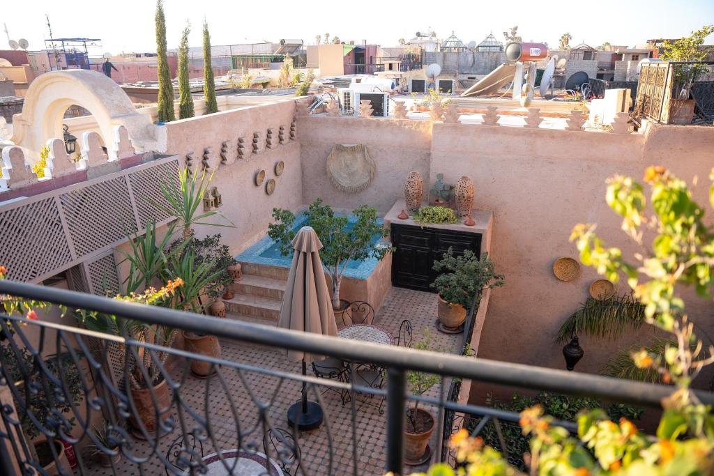 un balcón de un edificio con piscina y plantas en Riad Maud, en Marrakech