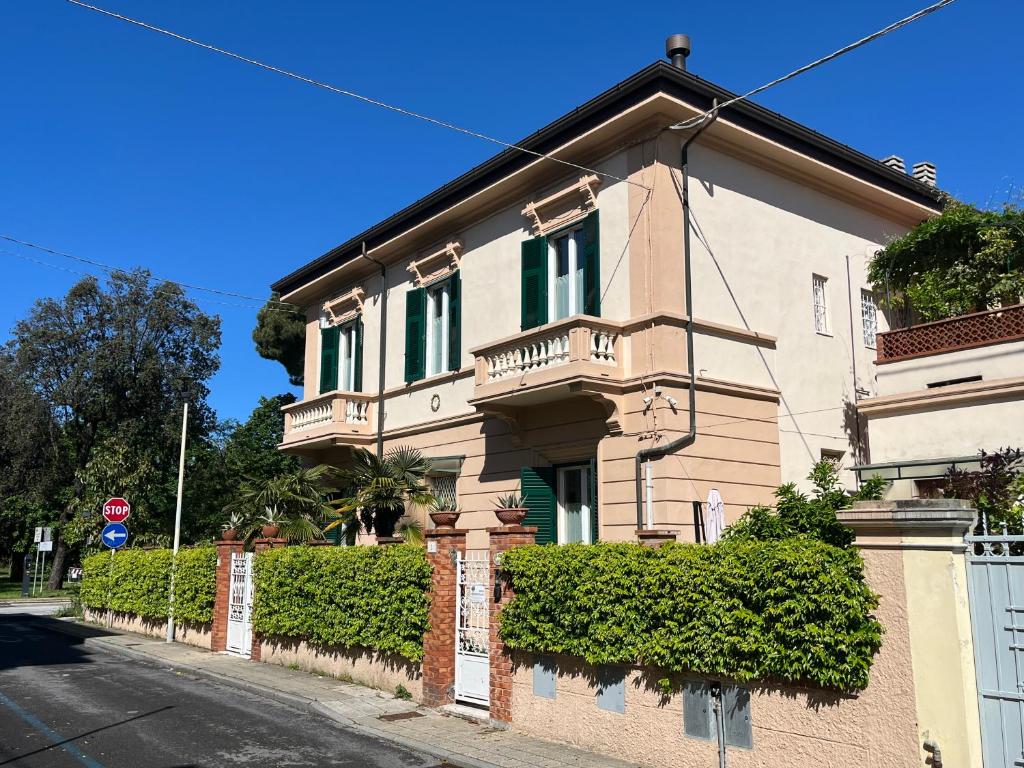 un edificio con ventanas verdes y una valla en Pura vida en Viareggio