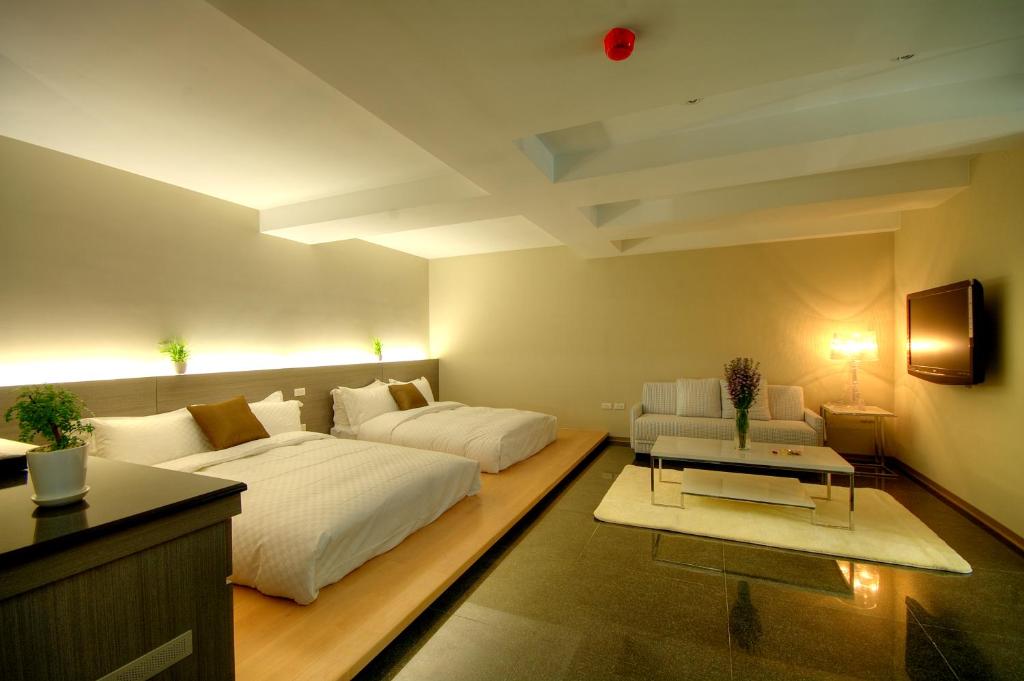 a large living room with a bed and a couch at Kapok Hotel &amp; Resorts in Luodong