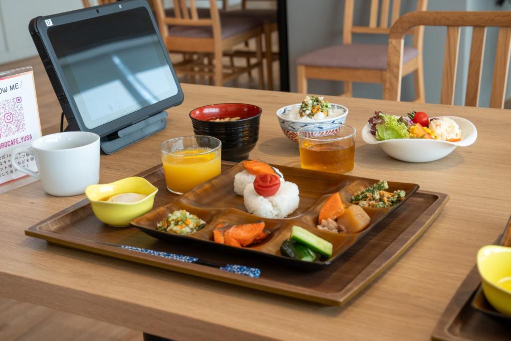 un plateau de nourriture sur une table avec une assiette de nourriture dans l'établissement Yuuyu No Sato Yusa, à Yamagata