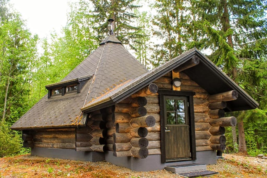 a log cabin in the woods with a door at Kuukkelin Koto in Hämeenlinna