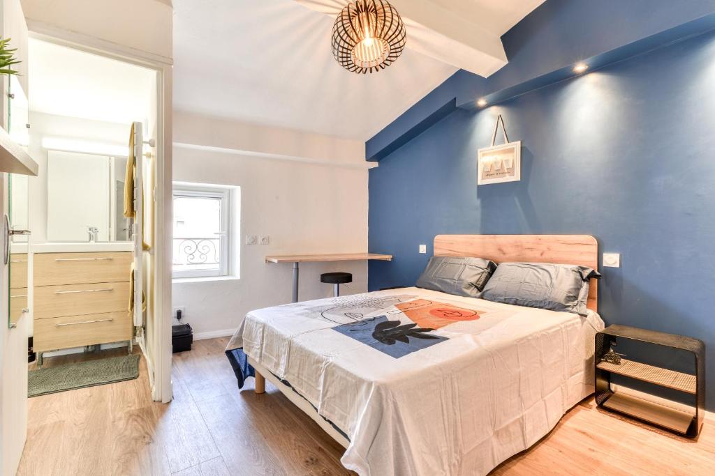 une chambre avec un lit et un mur bleu dans l'établissement Côté Palais 2-Climatisé-Netflix-Fibre, à Carcassonne